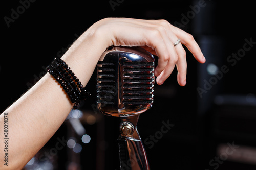 Female hand hold retro microphone