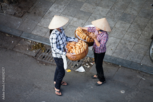 HANOI, VIETNAM - FEB 21: A small market for vendor in early morning in Hanoi, Vietnam on February 21, 2016. Vietnam florist vendor selling flowers on bicycle in small market or on street in Hanoi. photo