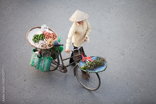 HANOI, VIETNAM - FEB 21: A small market for vendor in early morning in Hanoi, Vietnam on February 21, 2016. Vietnam florist vendor selling flowers on bicycle in small market or on street in Hanoi.
