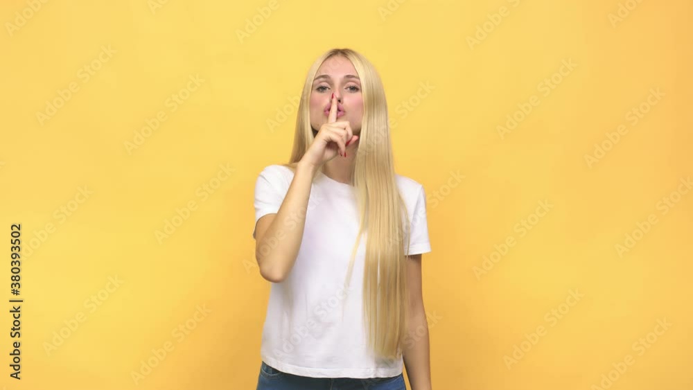 Young caucasian blonde woman keeping a secret or asking for silence Young caucasian blonde woman keeping a secret or asking for silence