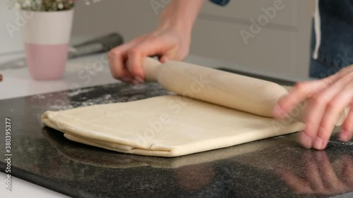 Female hands make puff yeast dough at home kitchen.