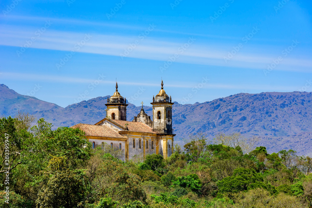Rear view of historic church in baroque and colonial style from the 18th century amid the hills and vegetation of the city Ouro Preto in Minas Gerais, Brazil