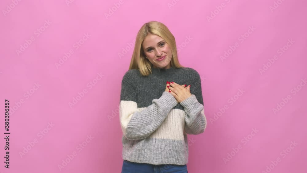 Young caucasian blonde woman has friendly expression, pressing palm to chest love concept Young caucasian blonde woman has friendly expression, pressing palm to chest love concept