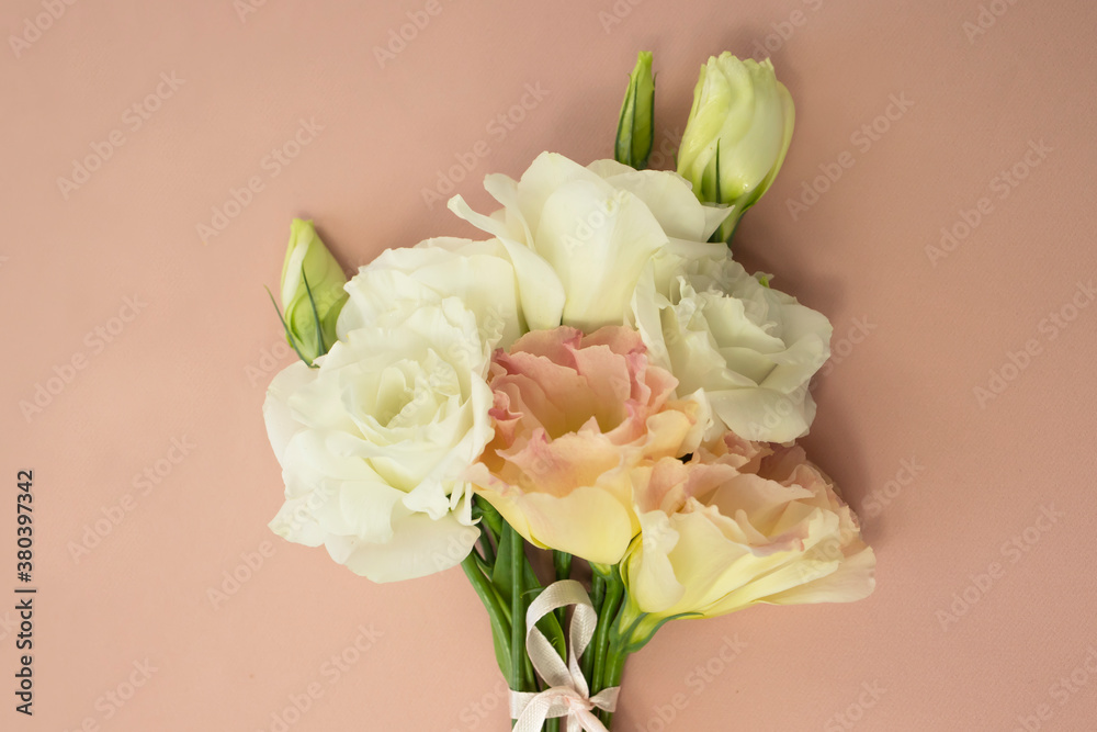 Fototapeta premium A bouquet of delicate fresh flowers on a pink background.