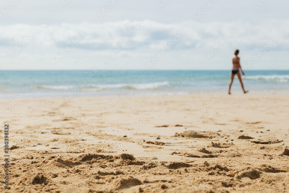 Woman Walking in a Sandy Beach Woman Walking in a Sandy Beach