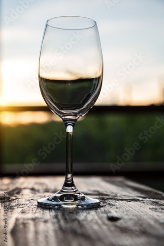 A glass of wine at sunset over the vineyards.