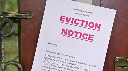 A resident's eviction notice is glued to the front door of the house, close-up