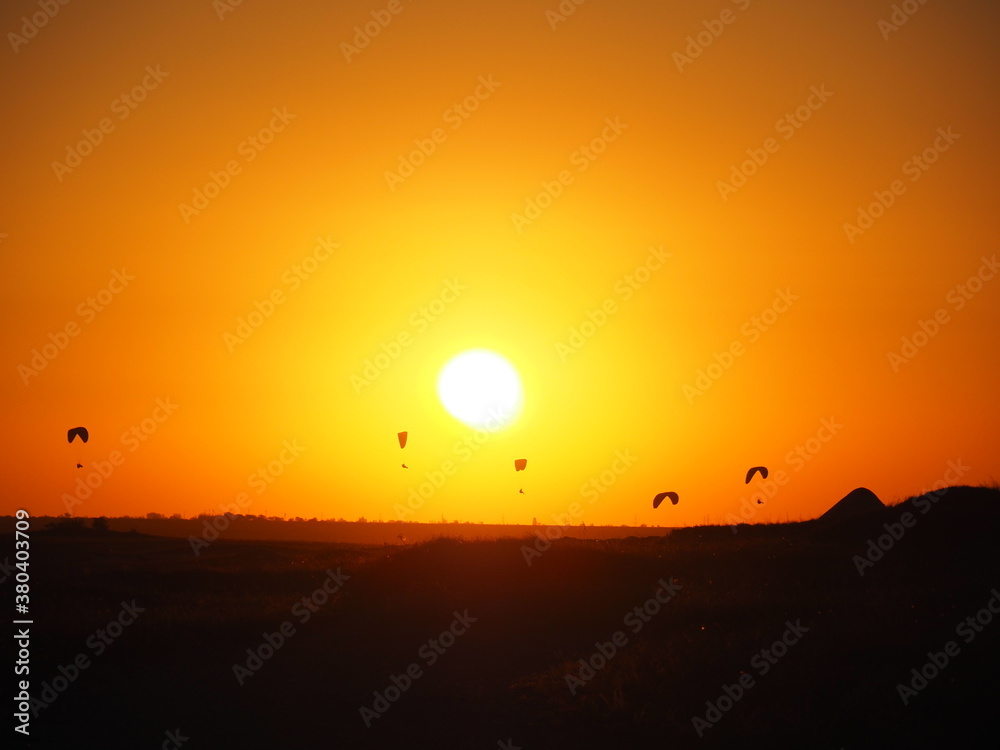 Skydivers at sunset