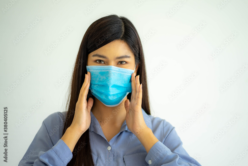 Young pretty Asian woman wearing protective face mask from virus pandemic on white background copy space. social distancing new normal concept. Young pretty Asian woman wearing protective face mask from virus pandemic on white background copy space. social distancing new normal concept.
