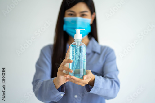 Young pretty Asian woman wearing protective face mask from virus pandemic on white background copy space. social distancing new normal concept.