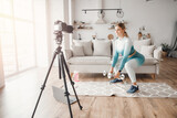 Fitness influencer woman recording video training home on camera. Concept Lifestyle blogger sport and recreation