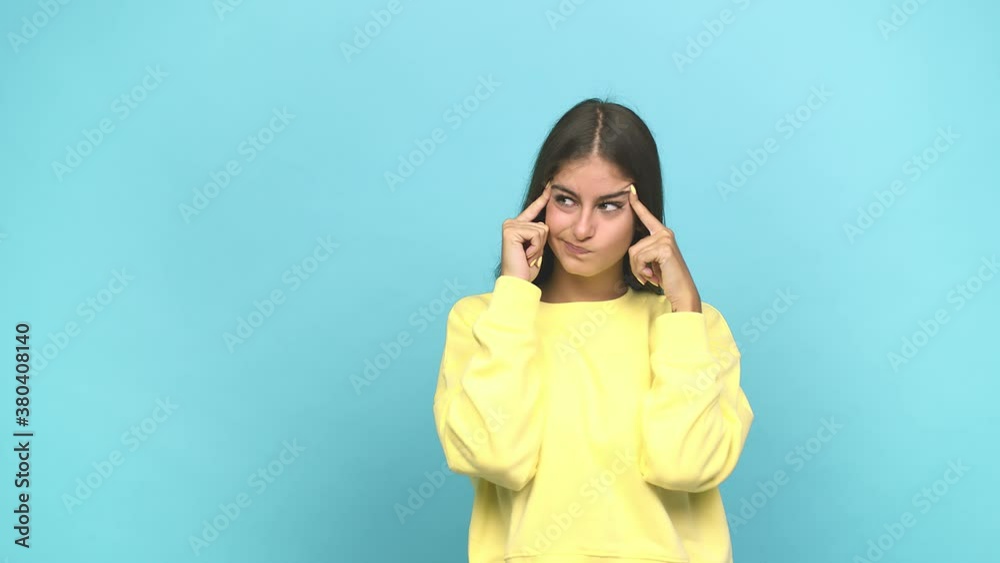 Young caucasian woman focused on a task, keeping forefingers pointing head Young caucasian woman focused on a task, keeping forefingers pointing head