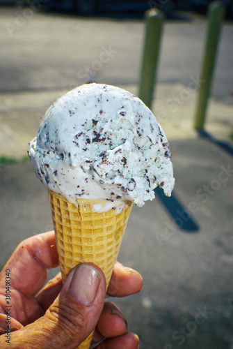 Mint chocolate chip ice cream cone in the hot sun.