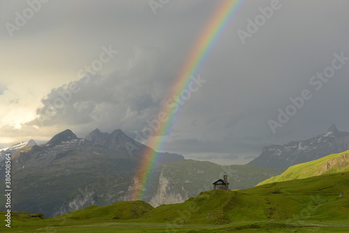 Regenbogenkapelle. Kleine Kirche in den Bergen mit Regenbogen