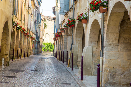 Stone buildings decorated with flower pots line the cobblestone steets in the village of Tarascon  France.