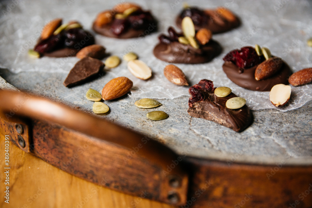 Chocolate with cranberry, pumpkin seeds, and almonds in a stone tray Chocolate with cranberry, pumpkin seeds, and almonds in a stone tray