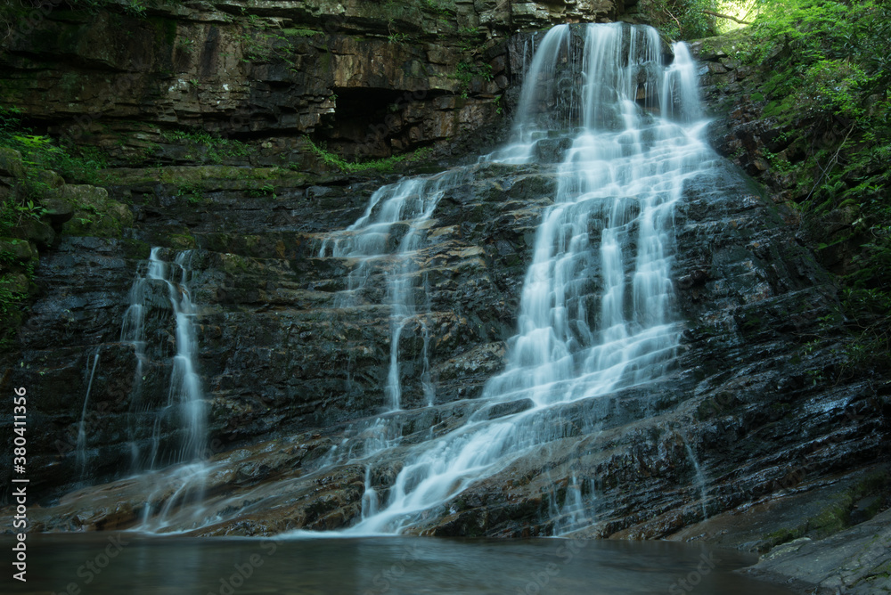 Obraz premium Beautiful reward for a spring hike to Margarette Falls on the West Fork Dry Creek in Greene County, Tennessee displaying a 60 foot, fan shaped waterfall with a lush green canopy.