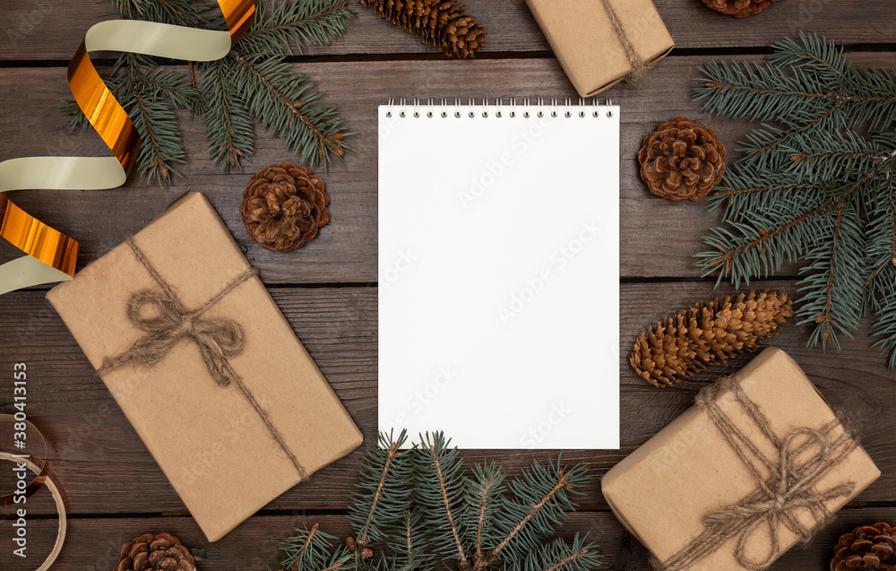 New Year's composition on a dark wooden table, in the center of a blank notebook. Mockup, template.