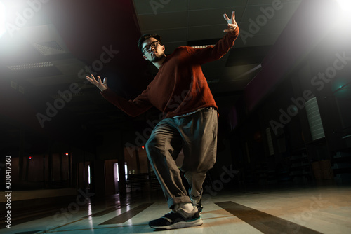 Professional break dancer posing in motion, practicing modern hip-hop dance in the studio © amixstudio