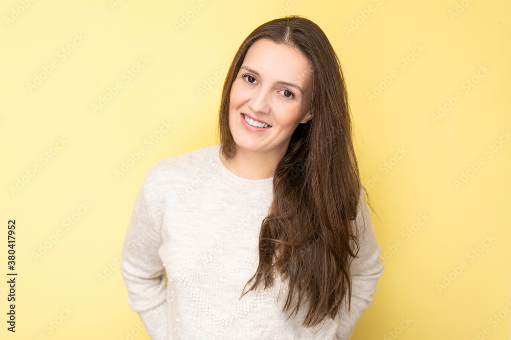 Obraz premium Happy attractive tatar young woman smiling and laughing isolated on yellow background with copy space, face portrait