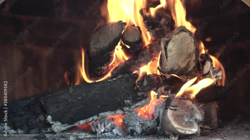Burning wood inside of a pizza oven with red orange flame and smoke Burning wood inside of a pizza oven with red orange flame and smoke
