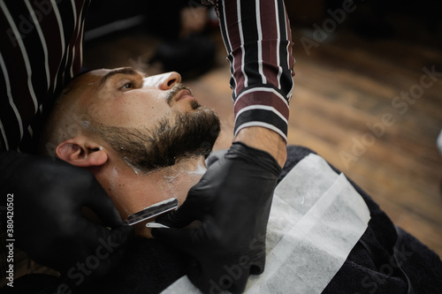 Photos a straight razor knife master shaves his beard to the client