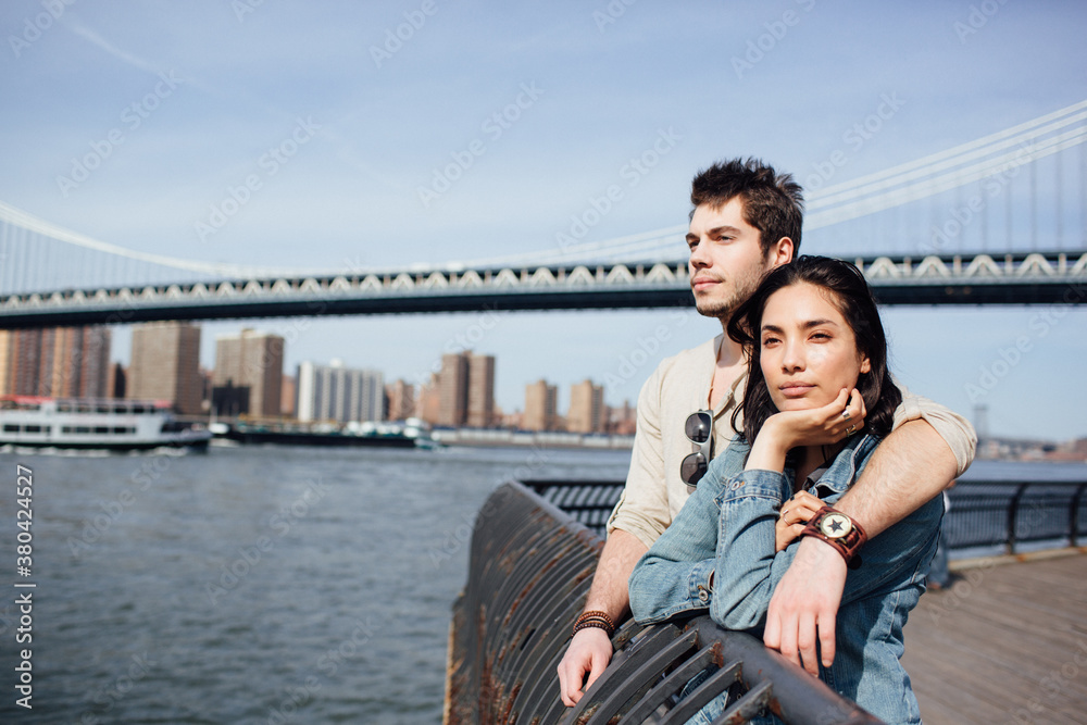Relaxed couple embracing on the riverbank, Brooklyn Relaxed couple embracing on the riverbank, Brooklyn