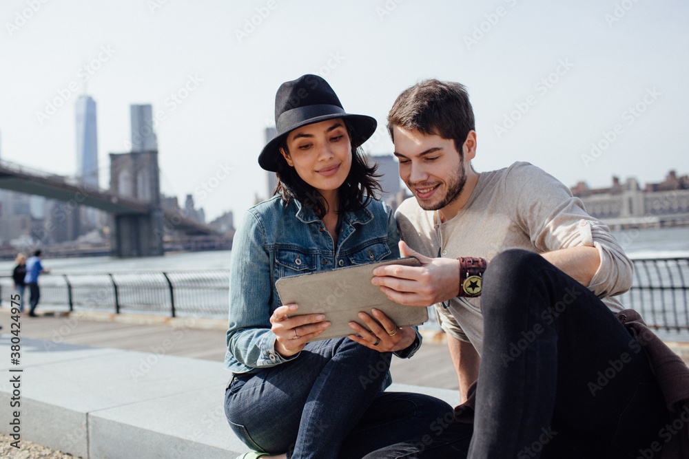 Attractive brunette using a digital tablet with her male friend Attractive brunette using a digital tablet with her male friend