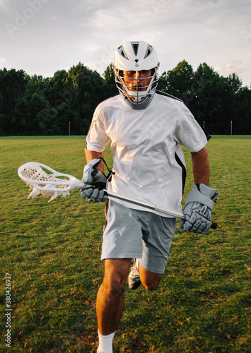 Man playing lacrosse sport and training in field photo