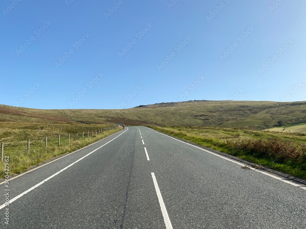 High on the moor tops, on Halifax Road, with a lone cyclist in the distance near, Sowerby Bridge, Yorkshire, UK
