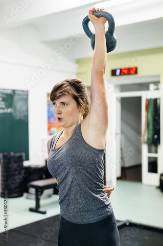 Woman In Gym Liftzing Kettlebells photo