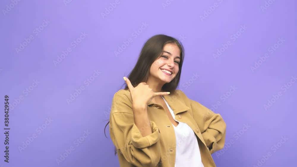 Young caucasian woman showing a mobile phone call gesture with fingers Young caucasian woman showing a mobile phone call gesture with fingers