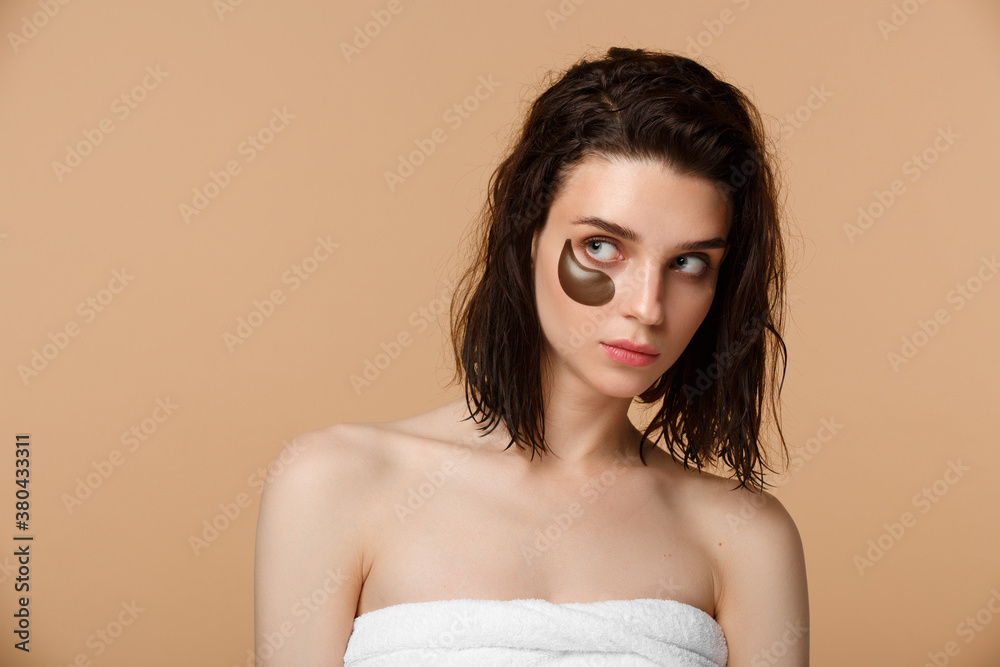 Woman applying under eye moisturising patches Woman applying under eye moisturising patches
