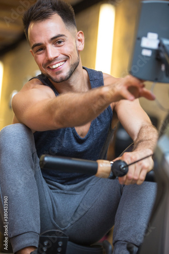 happy male athlete on rowing machine