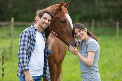 young beautiful couple with brown horse