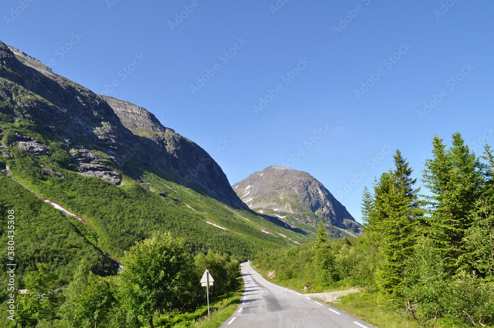 Road leading in a valley between mountains in Norway