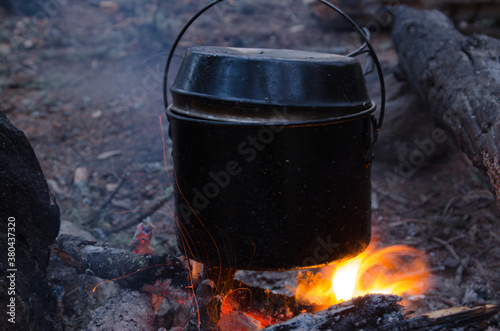 fire burns in the campaign. pot of tea by the fire.