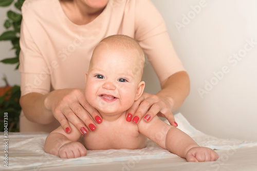 Massage the newborn close up. Female hands massage baby, newborn care concept, massage of abdominal colic, teething.