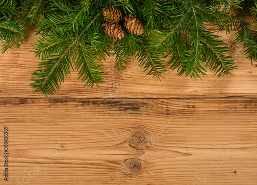 Close up fresh Christmas tree branches over wood