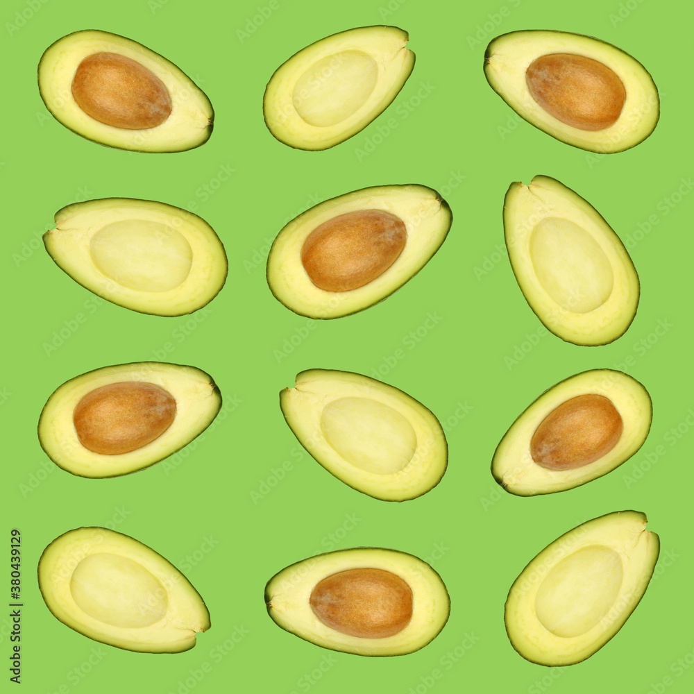 Pattern of fresh halved avocados over green Pattern of fresh halved avocados over green