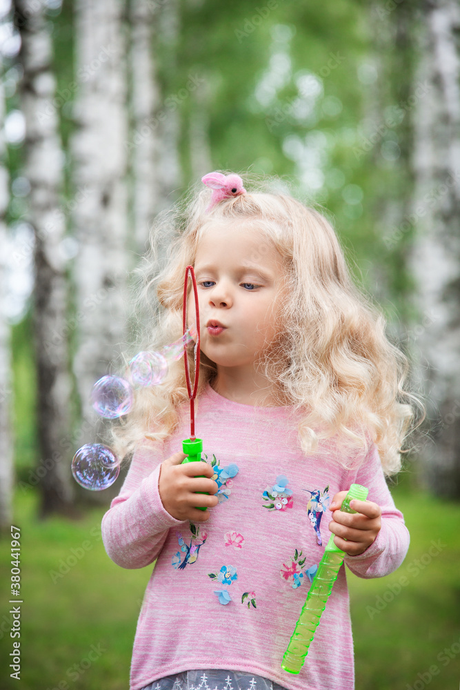 little girl with curly blonde hair on a walk, summer day little girl with curly blonde hair on a walk, summer day