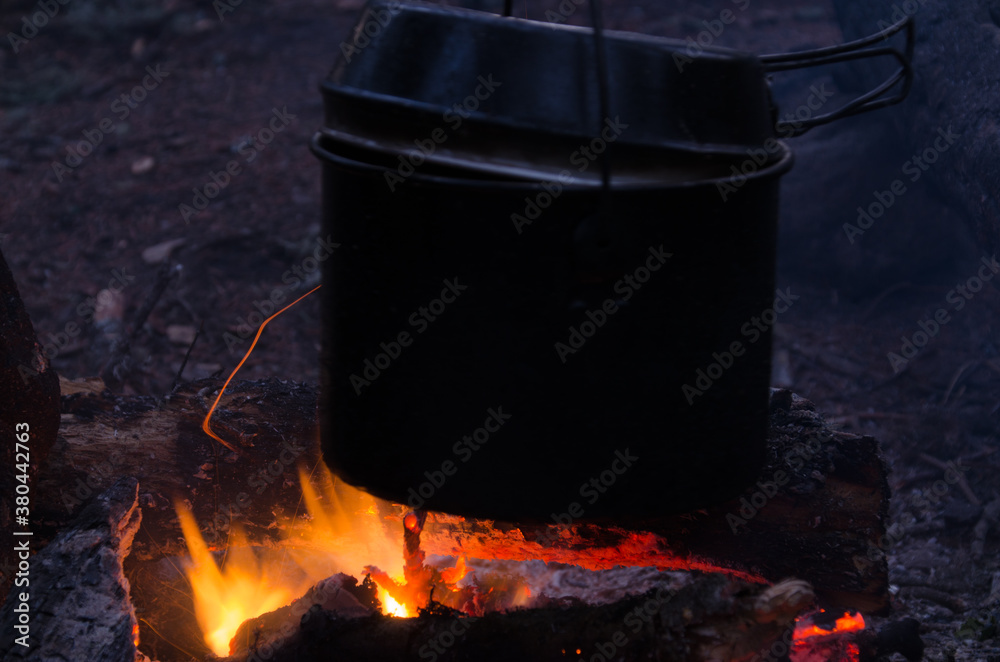 fire burns in the campaign. pot of tea by the fire. fire burns in the campaign. pot of tea by the fire.