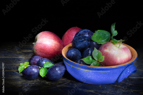 vaso in ceramica con mele e prugne photo