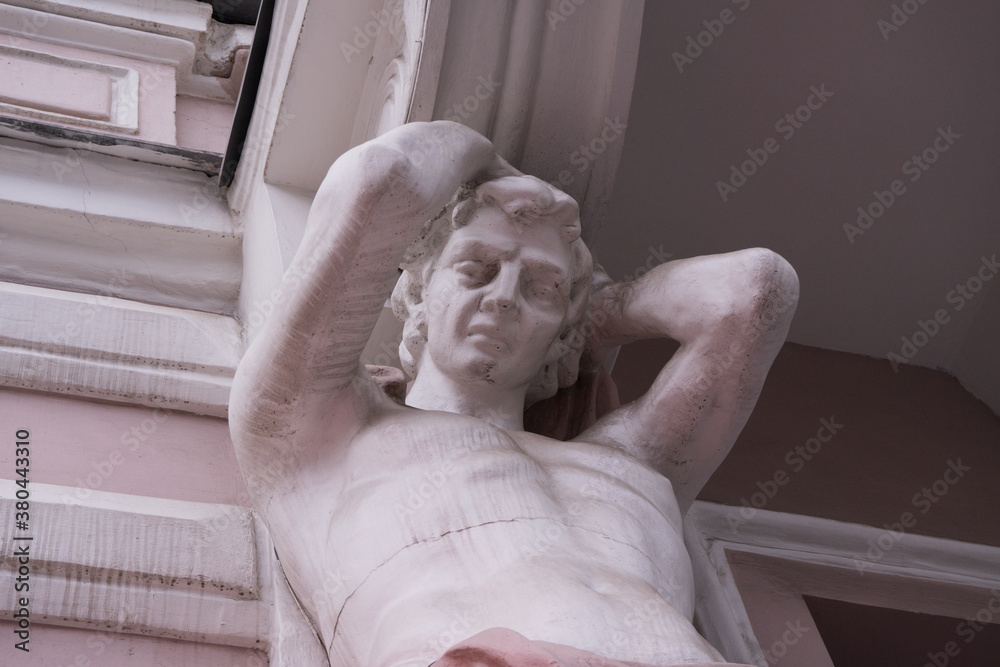 KHARKOV,UKRAINE 19 09 2020 Building decorated with sculpture of anchient strong body man Marble ornamental statue of greek God on the facade of historic building .Beautiful ancient architecture cocept