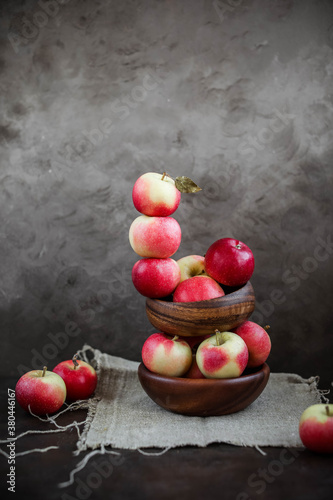 Lots of small apples in wooden bowls. Autumn harvest of fruits on a dark background.