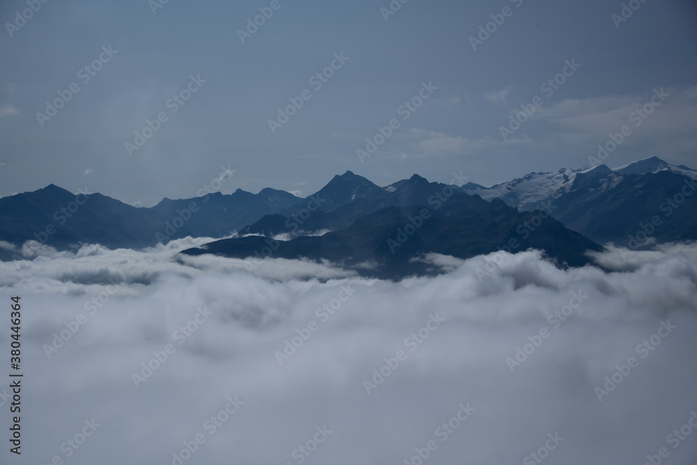 Mountain panorama of the Austrian Alps with low clouds