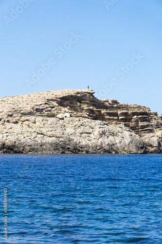 Man on a cliff overlooking the mediterranean sea photo