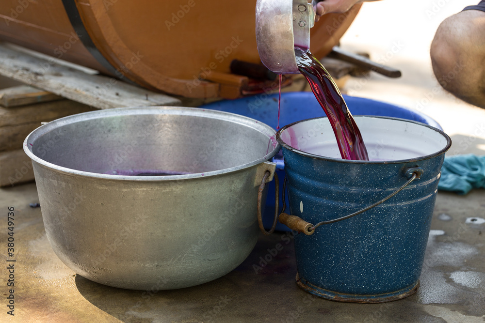 The winemaker pours grape juice for transportation into barrels.