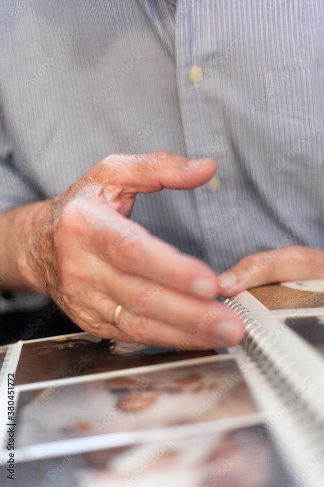 Hand of an old man going trough family photos Hand of an old man going trough family photos