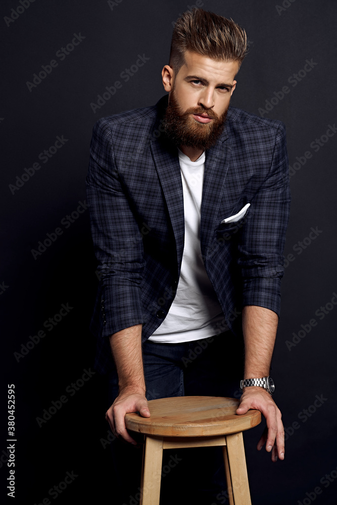 Confident and handsome. Full length of young man looking at camera while posing against black background Confident and handsome. Full length of young man looking at camera while posing against black background
